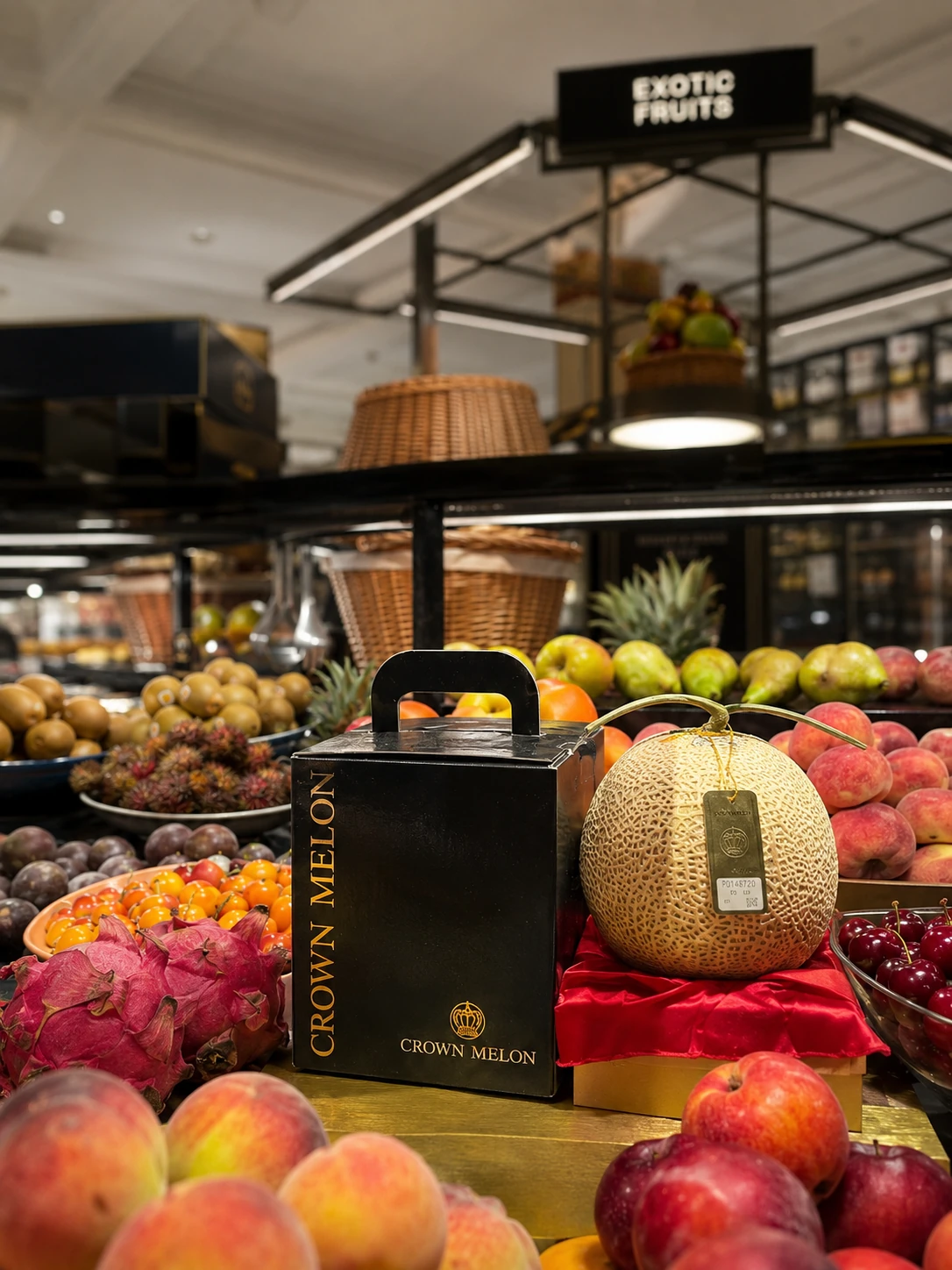 Crown Melon in its black and gold gift box, shown beside the netted melon on red silk at the Exotic Fruits counter of Harrods
