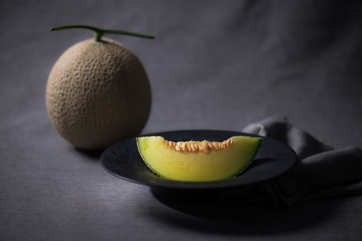 A whole Crown Melon resting before its moment